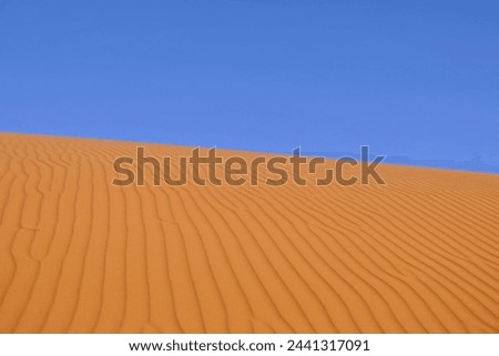 Abstract landscape of magnificent sandy dunes of desert land in soft warm sunlight with clear sky Royalty-Free Stock Photo #2441317091