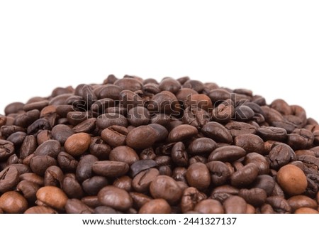 Pile of coffee beans in the center of a white table. Front view. Horizontal composition