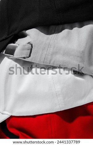Folded Baseball Caps in Red, Black, White and Grey on a White Background