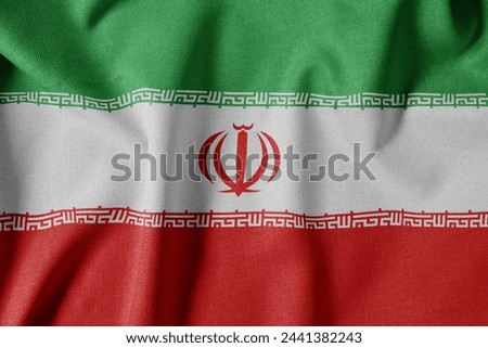 National Flag on Textured Fabric Background. Silk textured flag, realistic wave and flag look. IR  Flag of Iran Royalty-Free Stock Photo #2441382243