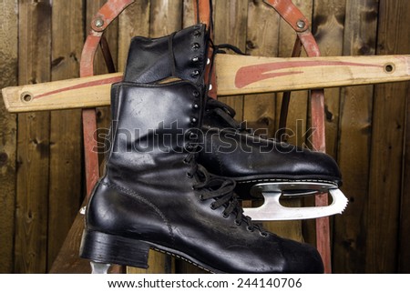 vintage ice skates hanging from old sled with rustic background
