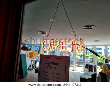 open letter in red neon light in the window of a cafe