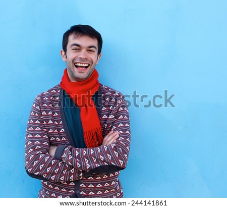 Portrait of a happy young man laughing with arms crossed 