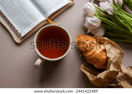 Open Bible, cup of tea and croissant, good morning.