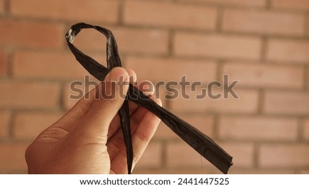 photo of someone's hand holding a raffia rope in the form of a ribbon