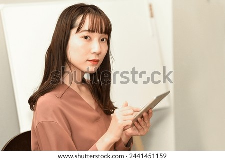 Young Asian woman operating a tablet device
