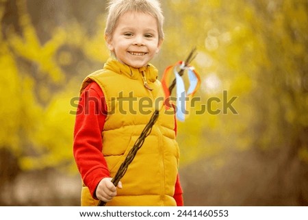 Cute preschool child, boy, holding handmade braided whip made from pussy willow, traditional symbol of Czech Easter used for whipping girls and women to receive eggs and sweets