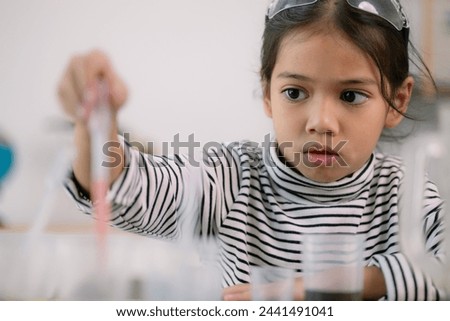 Asian child girl learning science chemistry with test tube making experiment at school laboratory. education, science, chemistry, and children's concepts. Early development of children.
