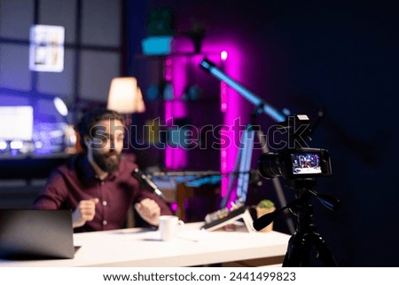 ASMR artist using quality mic and recording camera in studio to do anti stress video, whispering tingling sounds. Man using professional microphone and high tech gear to do sleep inducing content
