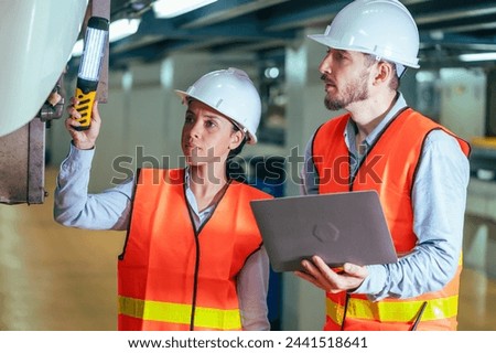 In this compelling stock photo, an engineer is captured in the dynamic environment of a train and railway garage, immersed in the meticulous tasks of maintenance, repair, or inspection.