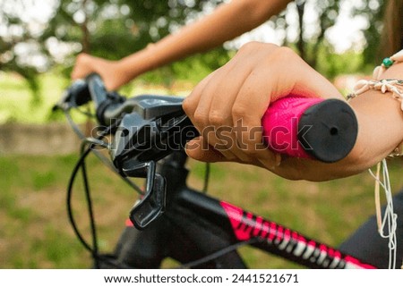 Left hand of a young Latin woman on a black bicycle in a Neiva park