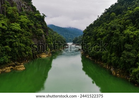 Wahrew river in Meghalaya. Passing through the mountains and clouds with green water .