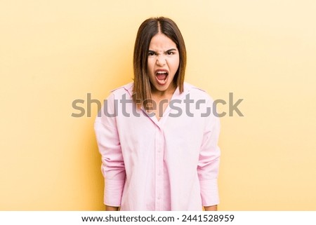 pretty hispanic woman feeling terrified and shocked, with mouth wide open in surprise
