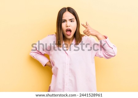 pretty hispanic woman pointing at camera with an angry aggressive expression looking like a furious, crazy boss