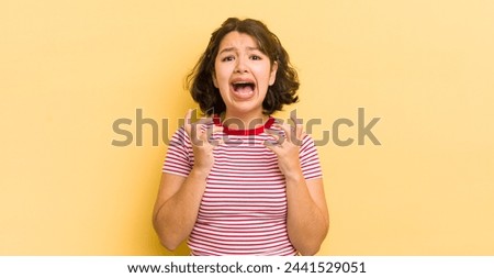 pretty hispanic woman looking desperate and frustrated, stressed, unhappy and annoyed, shouting and screaming