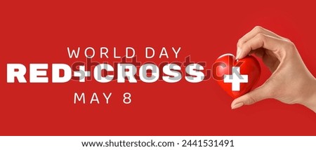 Hand with heart on color background. Banner for World Red Cross Day