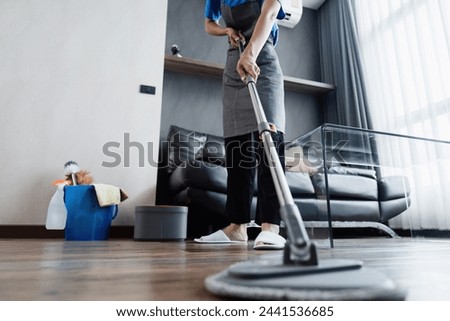 cleaning service housekeeper women swipe floor in living room. House cleaning service concept Royalty-Free Stock Photo #2441536685