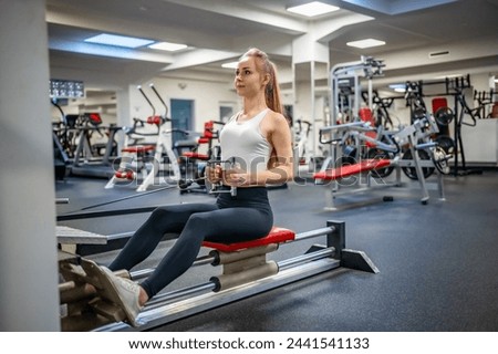  Young sport woman wearing sport wear doing exercise with fitness equipment at gym, she exercise for strong back and good healthy. High quality photo