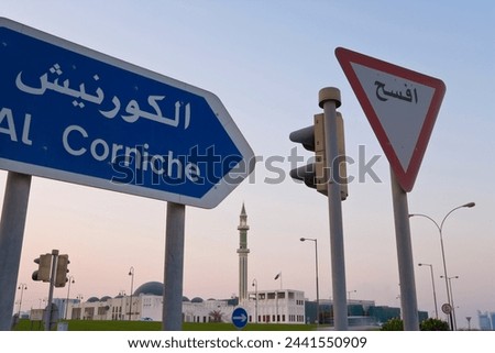 Road signs and minaret of the Grand Mosque iluminated at dusk, Doha, Qatar, Middle East