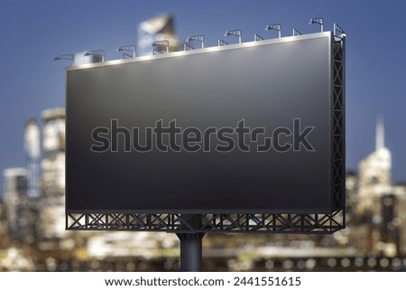 Blank black billboard on city buildings background at night, perspective view. Mockup, advertising concept