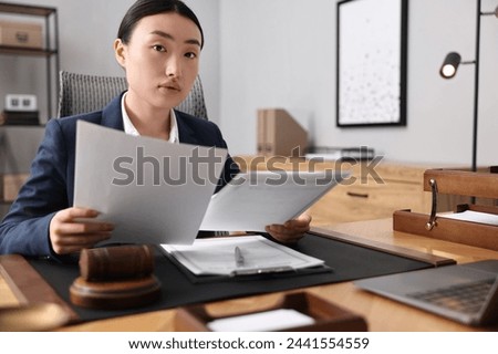 Notary reading documents at table in office