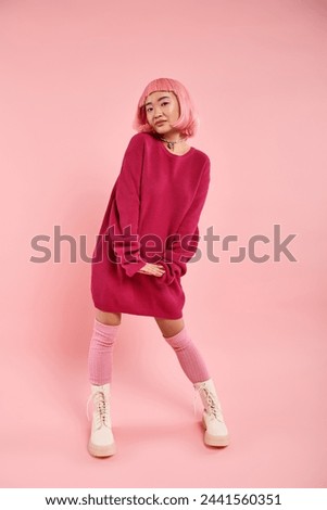charming asian young girl in vibrant sweater outfit cute posing on pink background