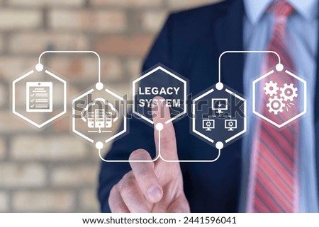 Businessman using virtual touch screen presses inscription: LEGACY SYSTEM. Legacy Systems Business Technology Interoperability Upgrade concept. Royalty-Free Stock Photo #2441596041