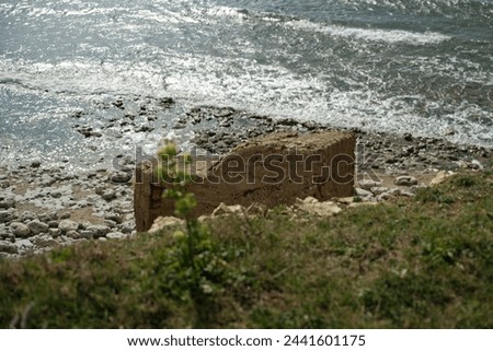 
blockhouse on the edge of the Atlantic Ocean. On the beach Royalty-Free Stock Photo #2441601175