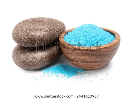 Light blue sea salt in bowl and spa stones isolated on white