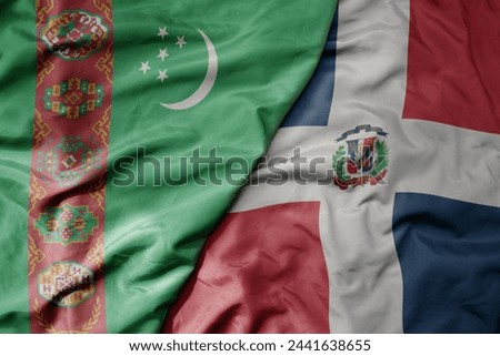 big waving national colorful flag of dominican republic and national flag of turkmenistan. macro
