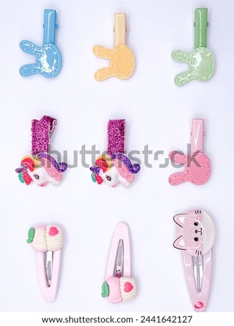 Hair Clips Plastic accessories adorned with unicorns, rainbows, and cartoon characters arranged against a white backdrop, adding a playful touch.