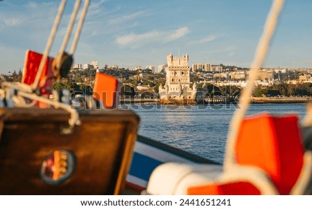 Stunning view from a boat of the iconic Belem Tower in Lisbon. A beautiful boat ride through the city center during the golden hour. Waiting for the sunset, seeing the city.