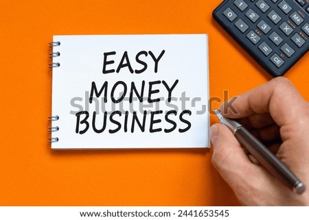 Easy money business symbol. Concept words Easy money business on beautiful white note. Beautiful orange background. Businessman hand. Calculator. Easy money business concept. Copy space.