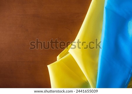 Flag of Ukraine and place for text on a dark wooden background