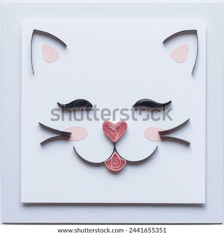 quilling card with cute cat face with heart nose. Little kitty. Love pets. making greeting cards. Hand made of paper quilling technique. Handicraft at home. Hobby, home office.