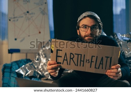 Championing Pseudoscience: Man Holding 'The Earth is Flat' Sign
