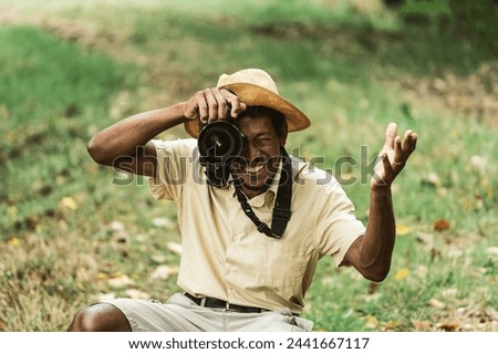Smiling photographer enjoying his passion outdoors. The cheerful expression as he captures moments in nature, sunlight enhancing the vivid scene. Photography concept into the nature.