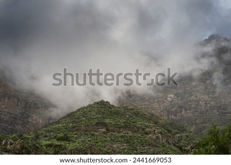 Tirajana mountains covered by low storm clouds in the background. Gran Canaria. Canary Islands