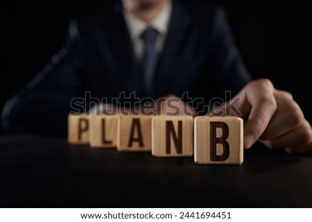 the hand highlights the letter B from the plan