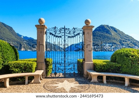 Old wrought iron gate overlooking Lake Lugano in Ciani Park, Lugano, Switzerland Royalty-Free Stock Photo #2441695473