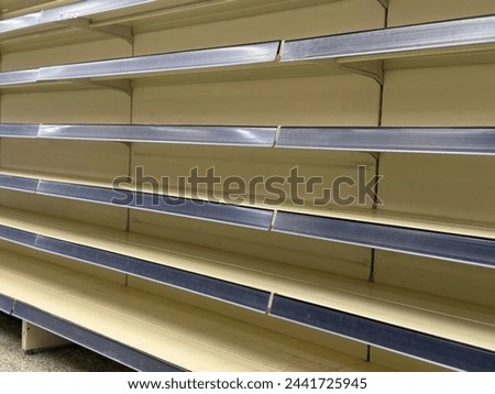 In supermarket empty shelves displaying an absence of goods for sale.