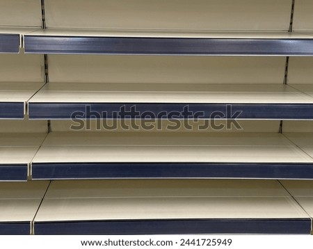 In supermarket empty shelves displaying an absence of goods for sale.