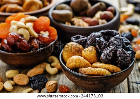 mix of dried fruits and nuts on a dark wood background. tinting. selective focus Royalty-Free Stock Photo #244173103