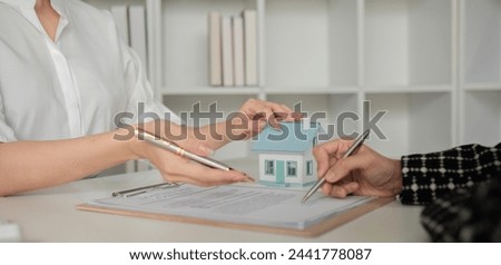 Real estate project representative and client signing documents house purchase contract book
