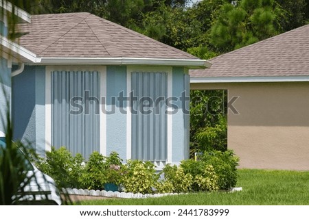 Steel storm shutters for hurricane protection of house windows. Protective measures before natural disaster in Florida Royalty-Free Stock Photo #2441783999