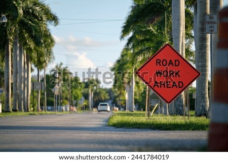 Road work ahead sign on street site as warning to cars about construction and utility works Royalty-Free Stock Photo #2441784019