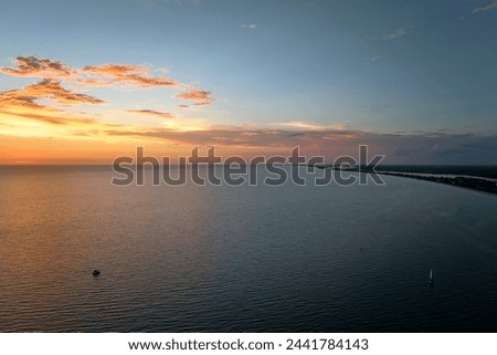 Aerial view of lonesome white yacht at sunset floating on sea waves with ripple surface. Motor boat recreation on ocean surface Royalty-Free Stock Photo #2441784143