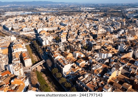View from drone of El Vendrell cityscape with brownish roofs of residential buildings on sunny winter day, Catalonia, Spain.. Royalty-Free Stock Photo #2441797143