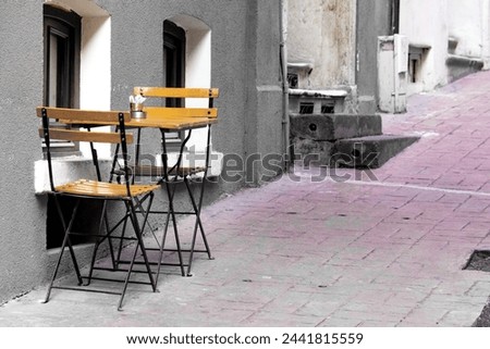 Chair and table in black and white photo. Cafe chairs and table on the sidewalk on a street in Beyoğlu, Istanbul. Horizontal photo. No people, nobody. Peaceful, quiet place. 