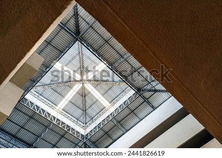 Warehouse Corrugated Ceiling with Cantilever Struts and a Skylight in Black and White. Roof designed with geometric shapes